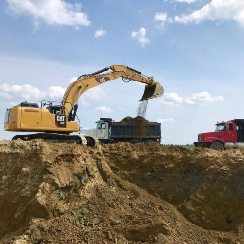 Large Excavator Releasing Soil From Dumptruck